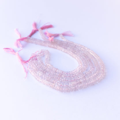 Handmade jewellery components featuring natural rose quartz smooth wheels with soft tones and polished glow.