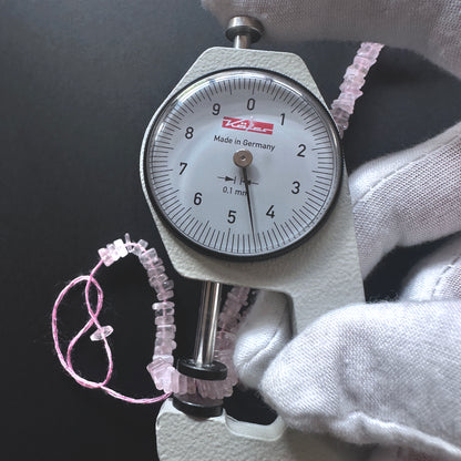 A dial gauge measures the Rose Quartz square heishi 4.5mm gemstone.