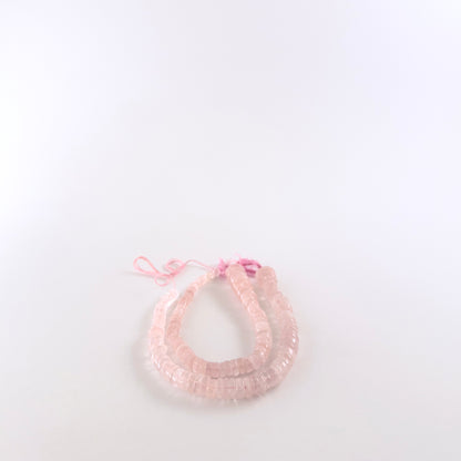 Rose Quartz wheel beads featuring smooth surfaces and a wide 5.5–12mm size gradient for a textured look.