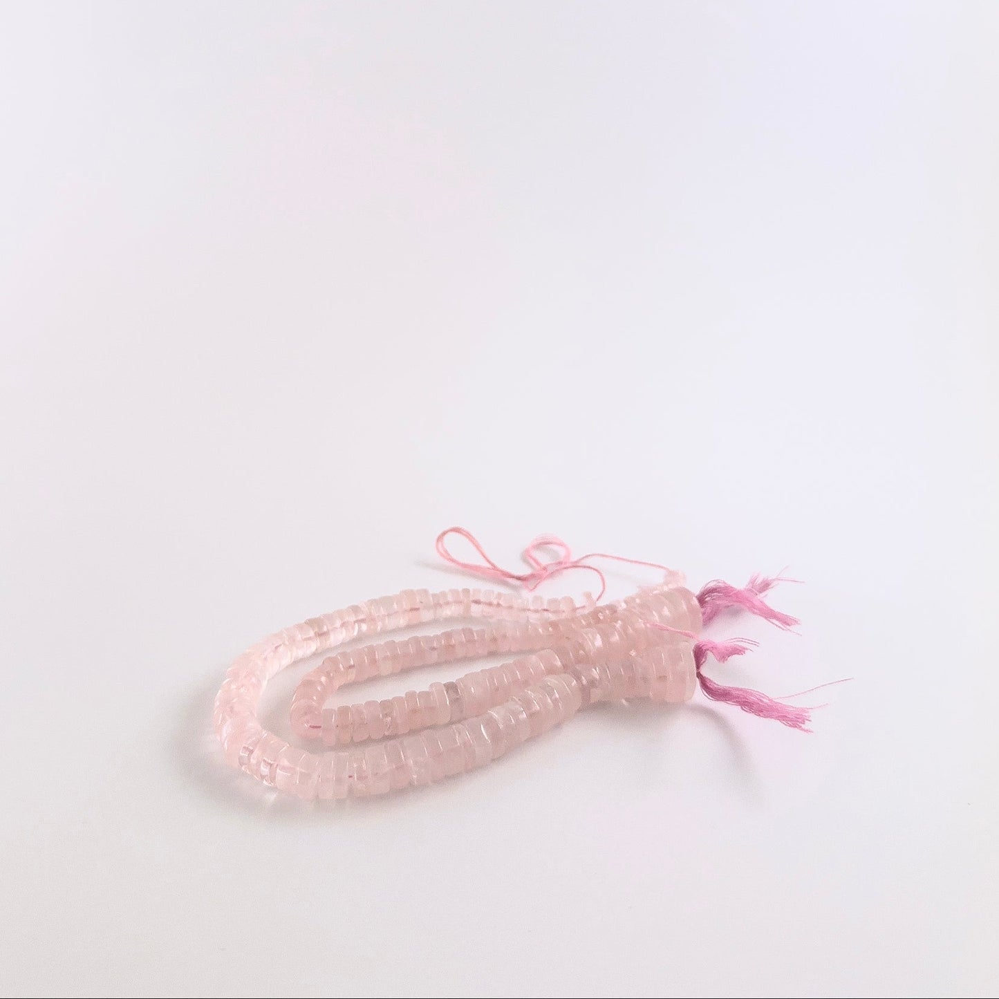 Rose Quartz gemstones in smooth wheel form, offering a sleek finish and pastel pink colouring.