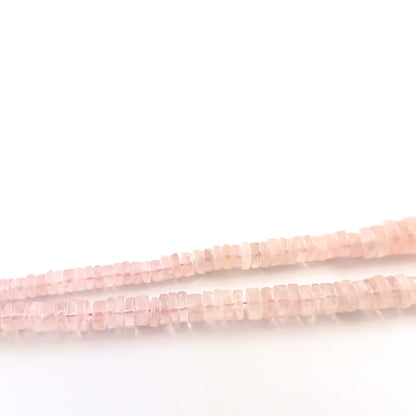 Rose Quartz wheel gemstones sized 5.5–12mm, arranged in a polished strand with varied proportions.