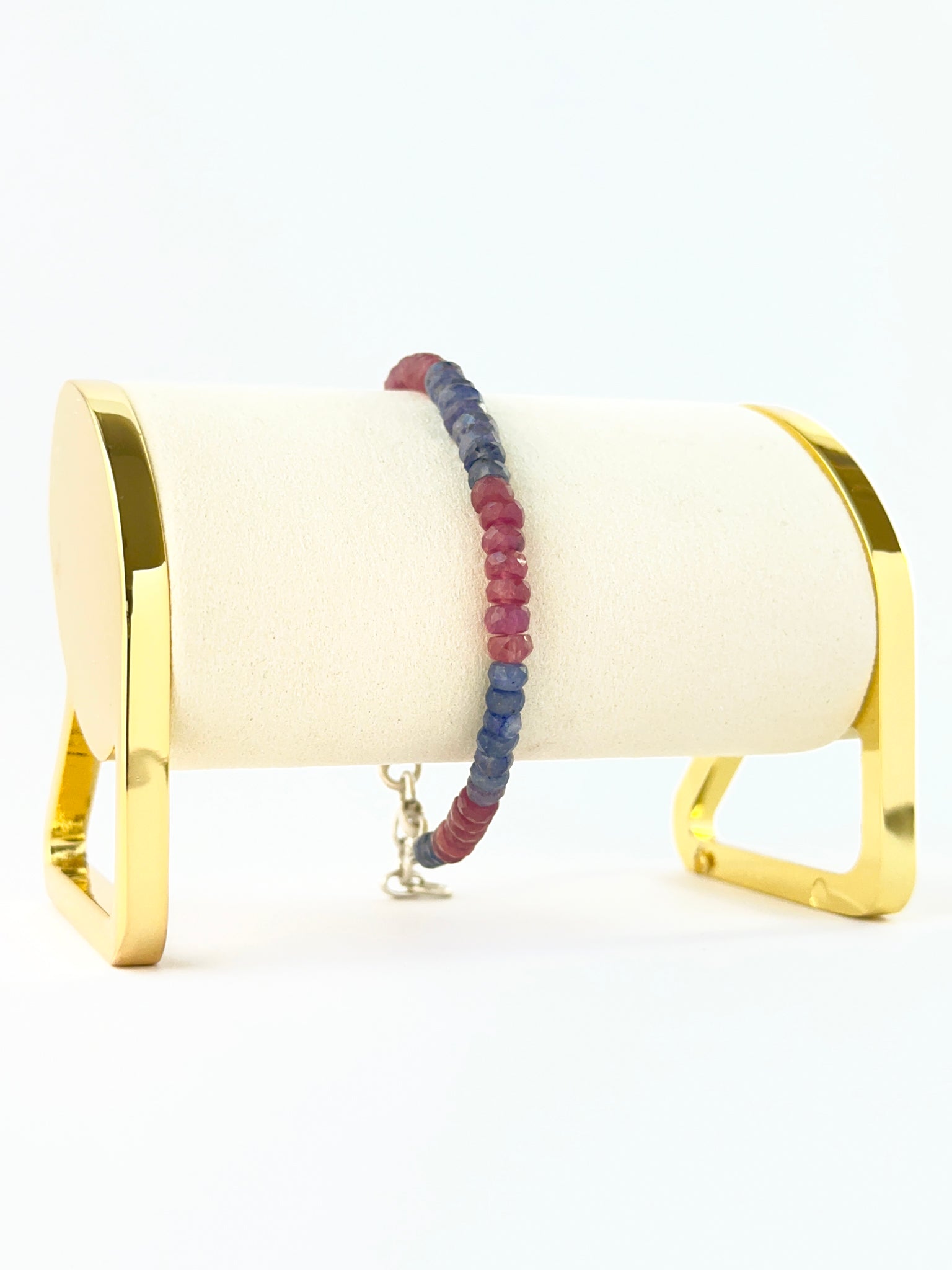 Bracelet featuring faceted rondelle ruby and blue sapphire 5mm beads in an 18cm adjustable design.