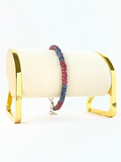 Bracelet featuring faceted rondelle ruby and blue sapphire 5mm beads in an 18cm adjustable design.