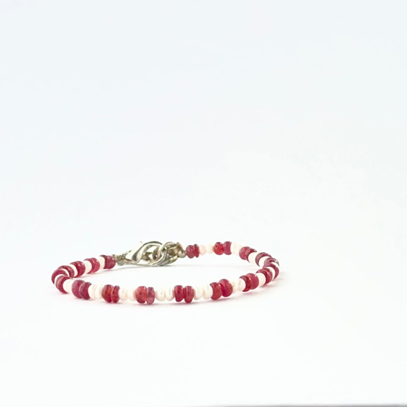 Ruby and freshwater pearl bracelet crafted with smooth rondelle 3.7–4mm beads and adjustable fit.