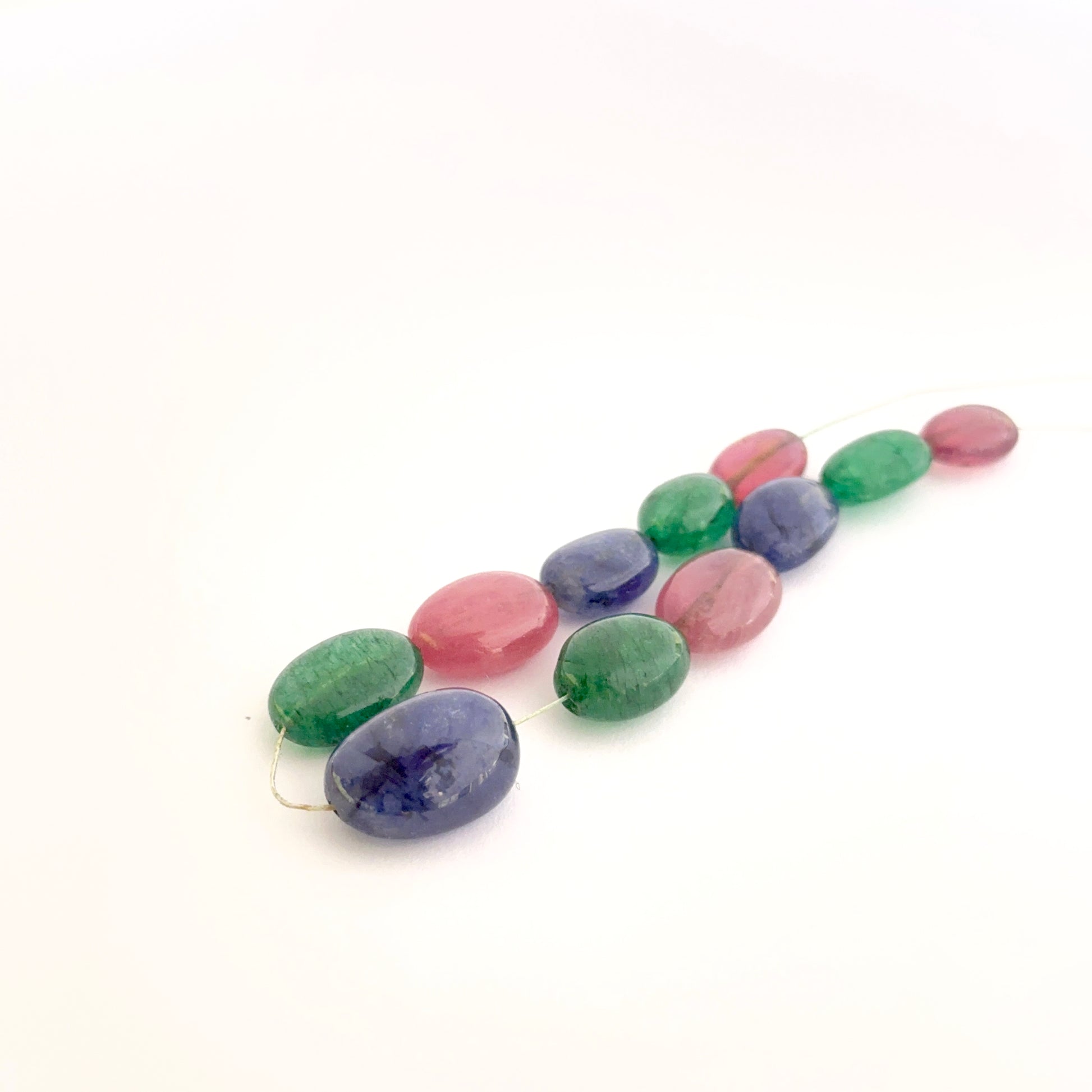 Mixed precious gemstone ovals displayed with glossy surfaces ideal for handmade jewellery components.