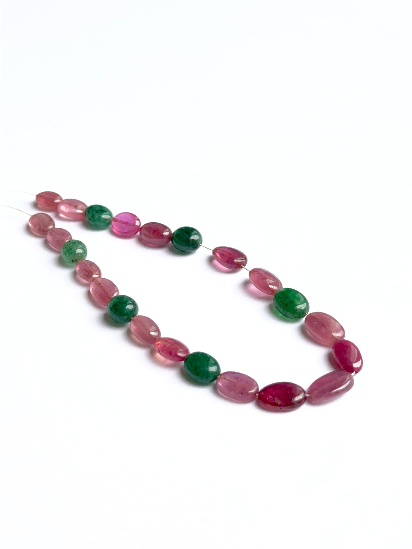 Ruby and beryl emerald smooth oval beads showing rich red and green tones for handmade jewellery.