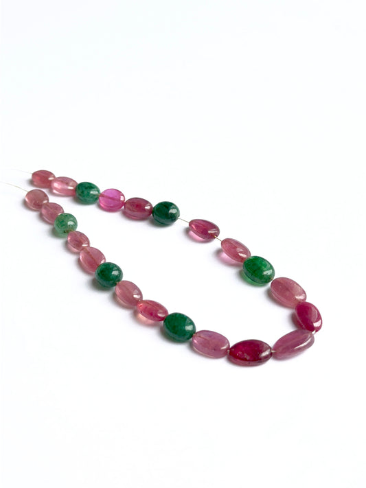 Ruby and beryl emerald smooth oval beads showing rich red and green tones for handmade jewellery.