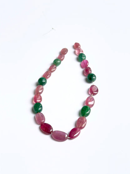 Close‑up of ruby and emerald smooth ovals highlighting their polished finish and gemstone colour.