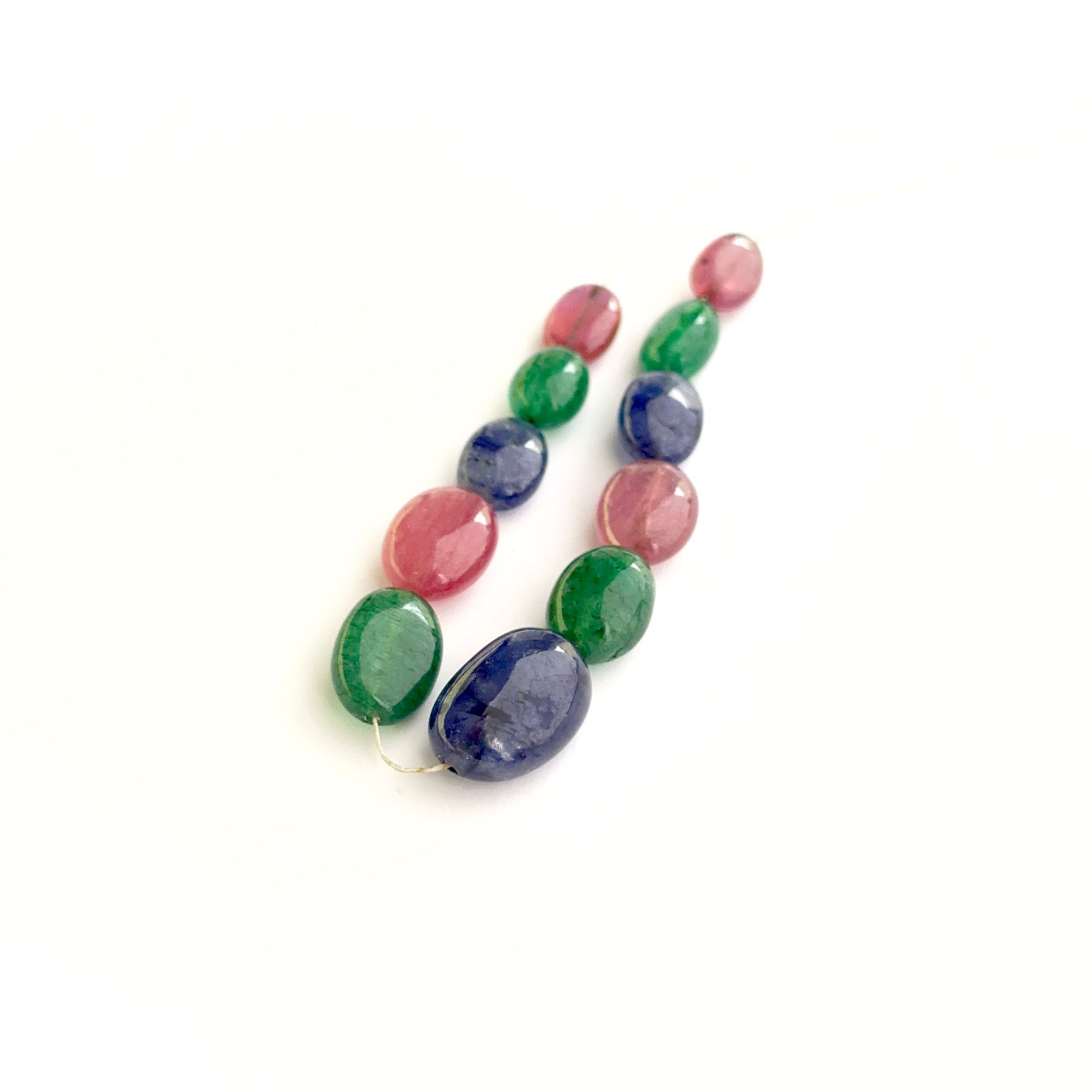 Multi precious smooth oval beads showing ruby, sapphire and emerald colours for handmade jewellery.