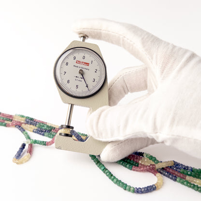 A dial gauge measures the Multi Precious Ruby Blue Sapphire Yellow Sapphire and Emerald Faceted Rondelle 3.8-4mm gemstone.