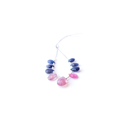 Genuine Ruby and Blue Sapphire faceted briolette gemstone beads arranged to show their vivid sparkle.