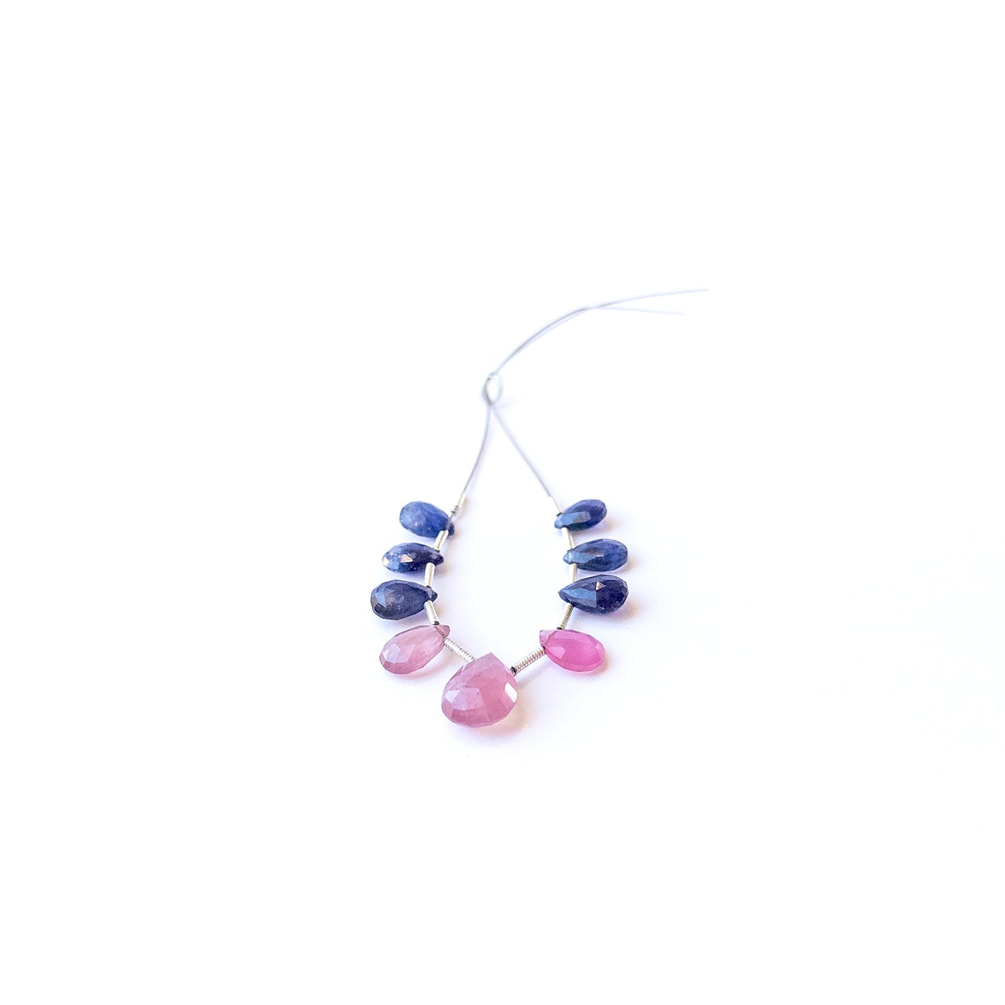 Ruby and Blue Sapphire briolette gemstone beads displaying polished facets and rich colour tones.