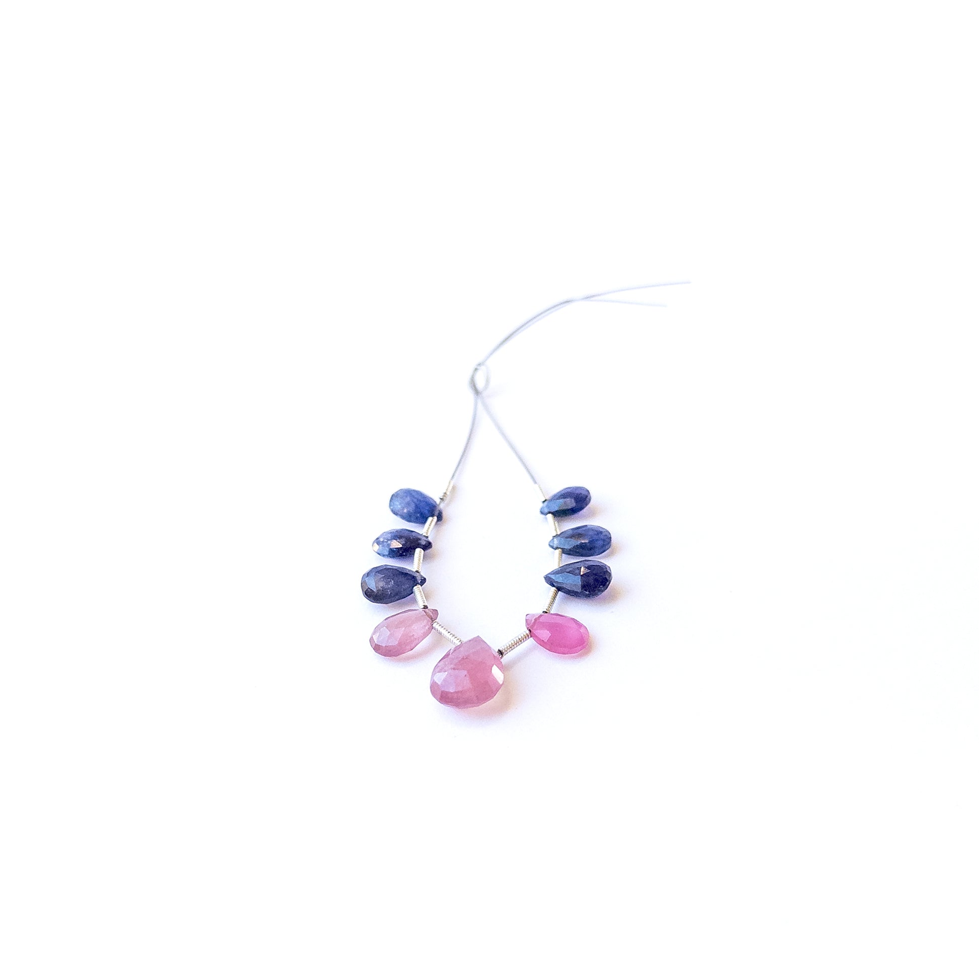 Ruby and Blue Sapphire briolette gemstone beads displaying polished facets and rich colour tones.