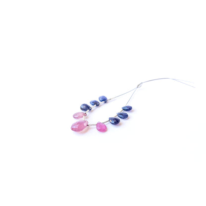 Premium faceted briolette beads in Ruby and Sapphire arranged neatly for jewellery design inspiration.