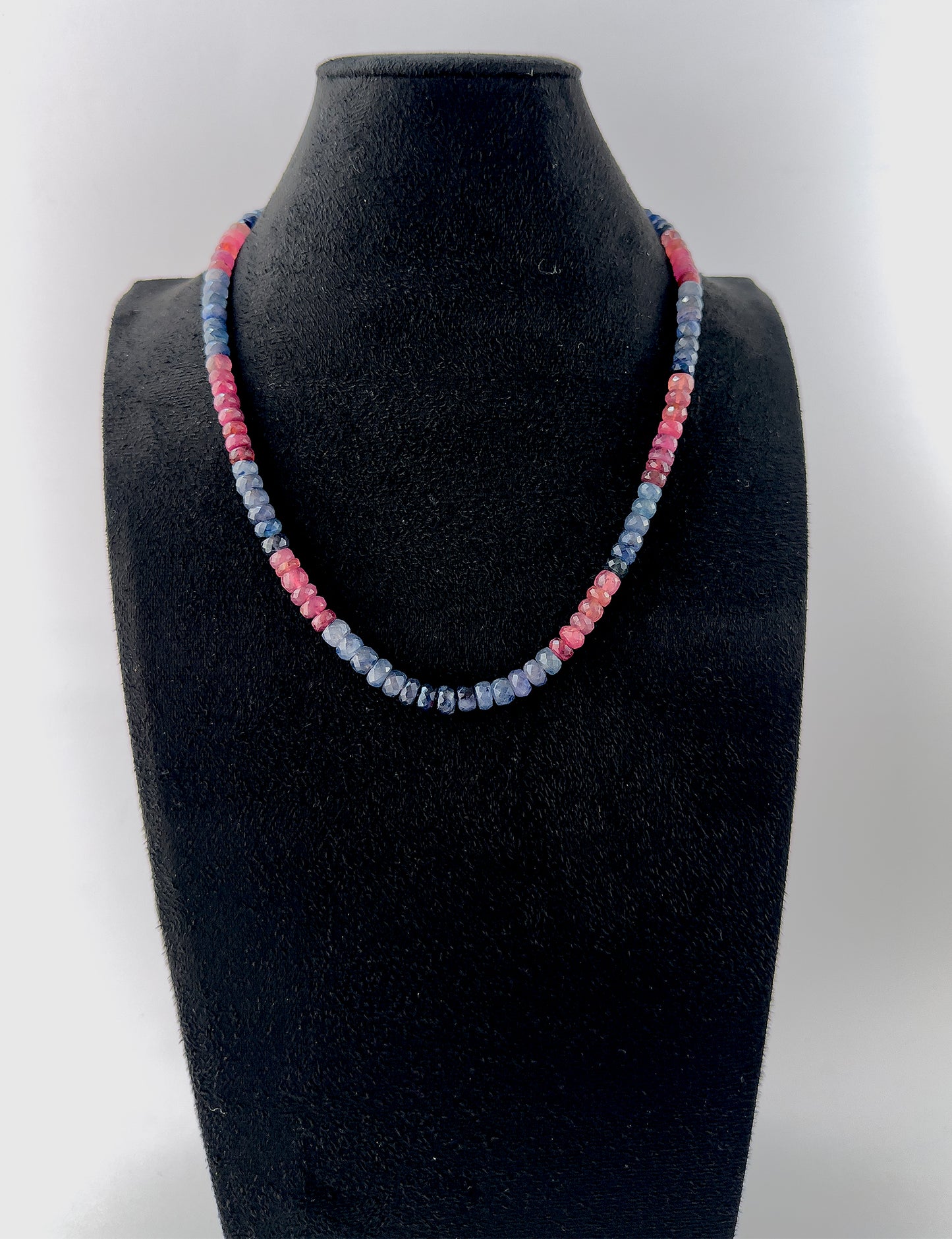 Handcrafted necklace combining Ruby and Blue Sapphire gemstone beads, cut in faceted rondelle shapes for refined shine.