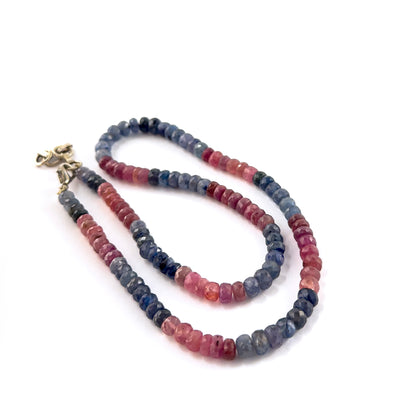 Close‑up of Ruby and Blue Sapphire faceted rondelle beads highlighting their polished facets and striking dual‑tone palette.