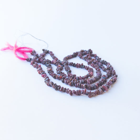 Handmade jewellery components featuring smooth Ruby chip beads in a neatly arranged strand.
