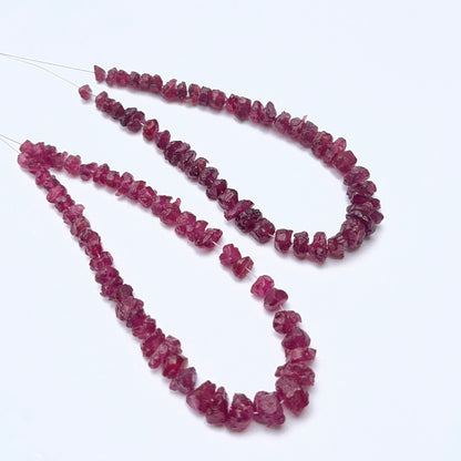 Ruby strand featuring drilled rough ruby beads with raw texture and deep red tones.