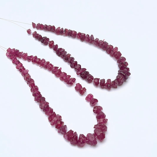 Ruby strand featuring drilled rough ruby beads with raw texture and deep red tones.