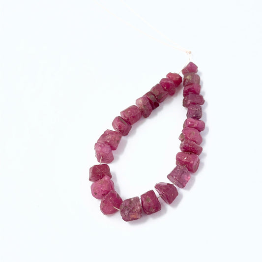 Close‑up of Ruby rough beads arranged in a strand with visible inclusions.