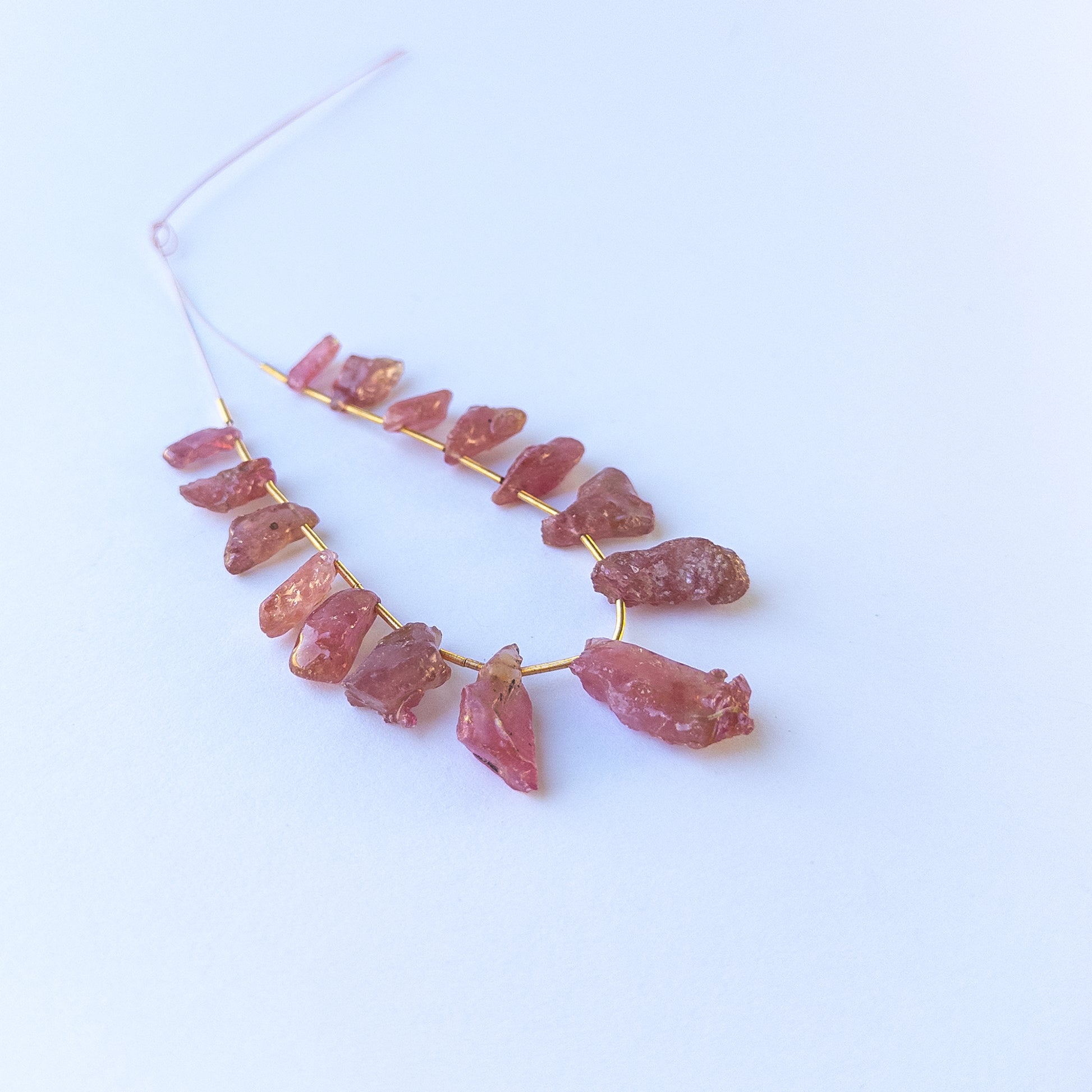 Handmade jewellery components with natural ruby drilled rough beads arranged in a 15‑piece set.