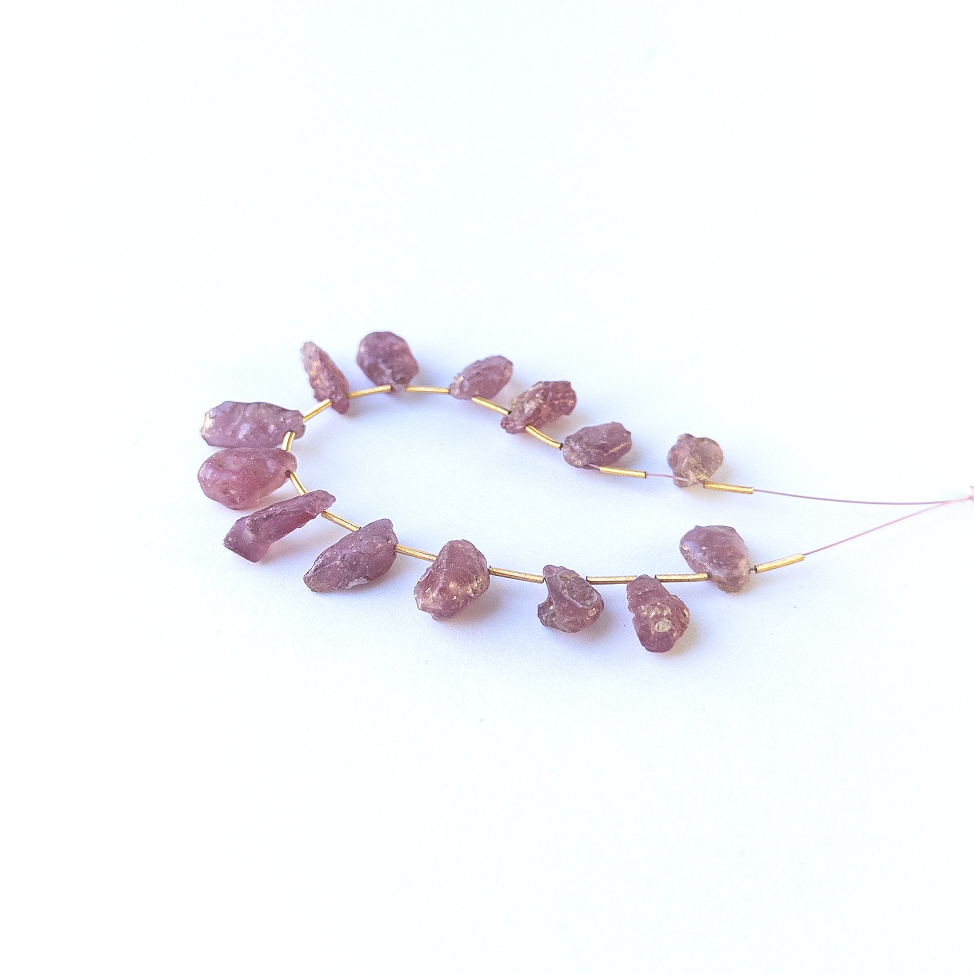 Authentic Ruby drilled rough beads showcasing organic crystal form and vibrant red hues.