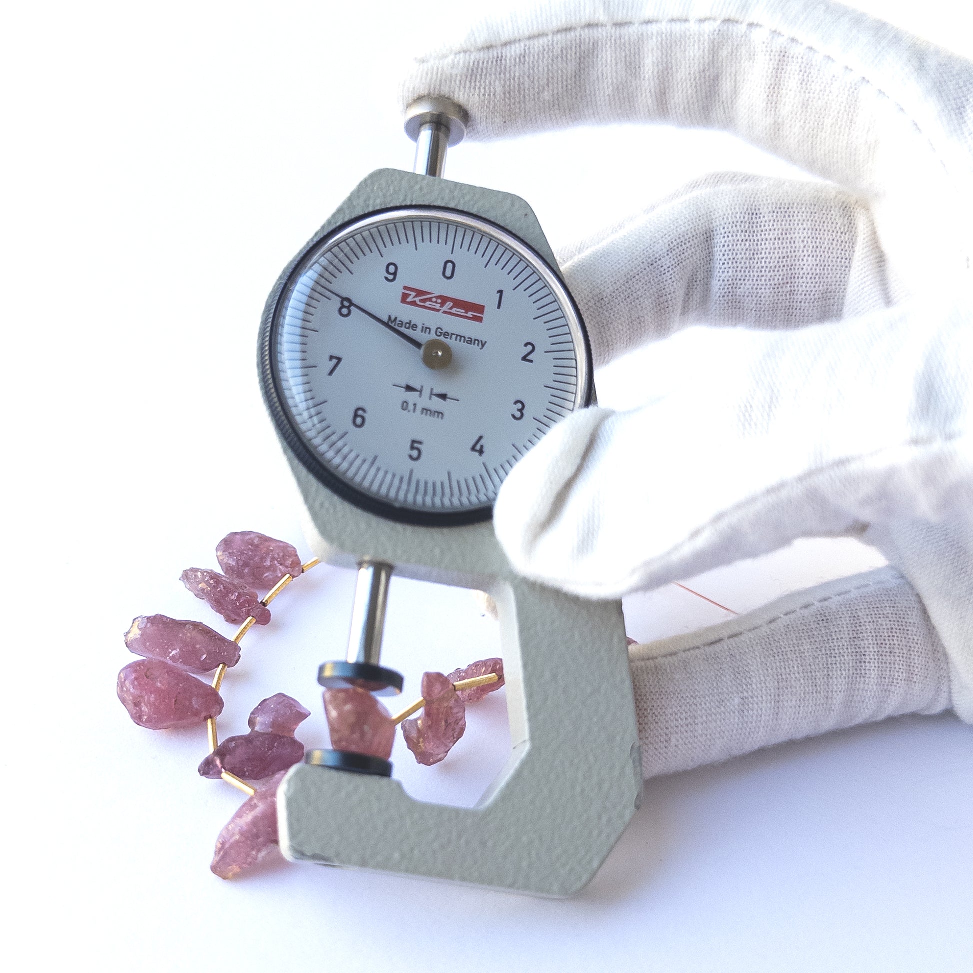 A dial gauge measures the Ruby drilled rough 8–9mm gemstone.