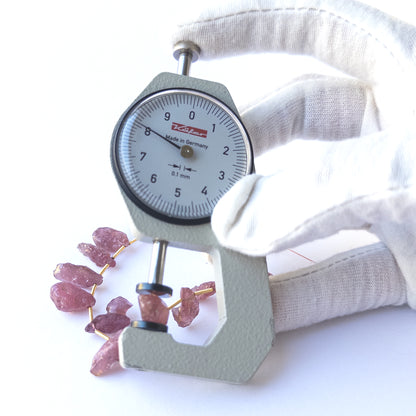 A dial gauge measures the Ruby drilled rough 8–9mm gemstone.
