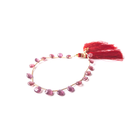 Elegant Ruby gemstone beads in briolette shape, arranged to highlight their natural brilliance.