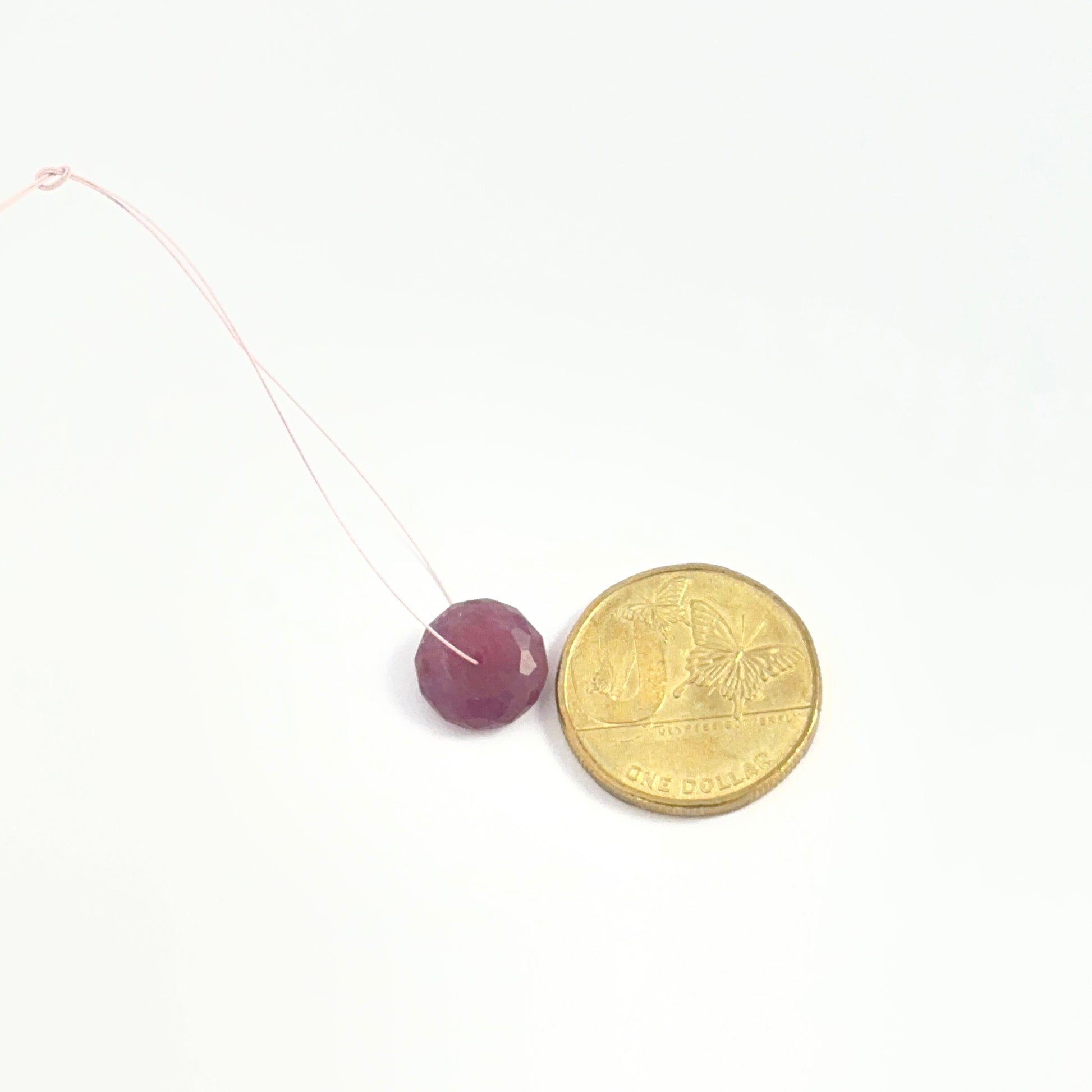 High‑quality faceted Ruby bead for handcrafted necklaces and jewellery projects, placed next to a coin for scale.