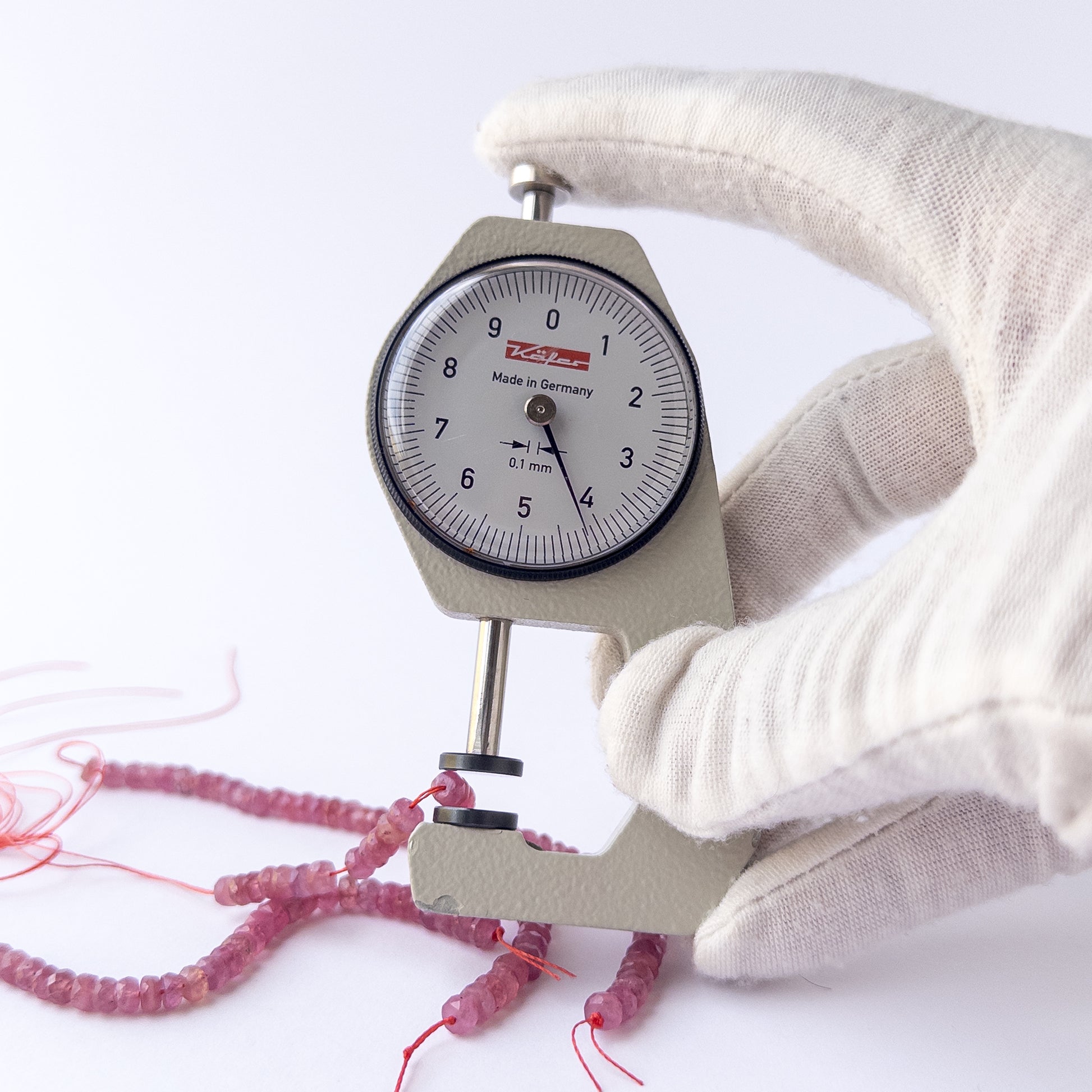 A dial gauge measures the Ruby faceted rondelle 4.2mm gemstone.