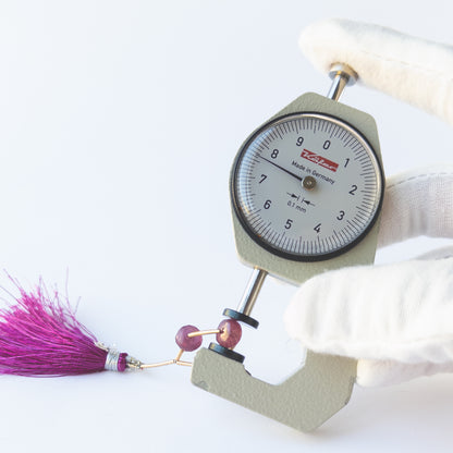A dial gauge measuring the Ruby faceted rondelle 7.3–7.6mm beads.