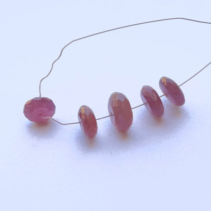 Close-up of gemstone beads showing ruby colour and faceted shine.