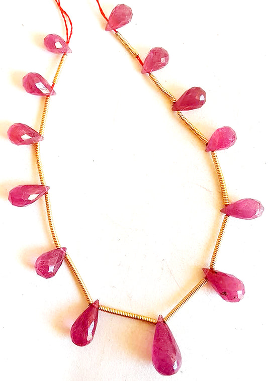 Faceted ruby teardrop beads in deep red tones with radiant sparkle and elegant symmetry.