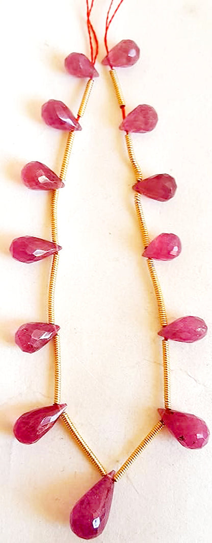 Close-up of ruby gemstone beads featuring faceted teardrop cut and vivid crimson hues.