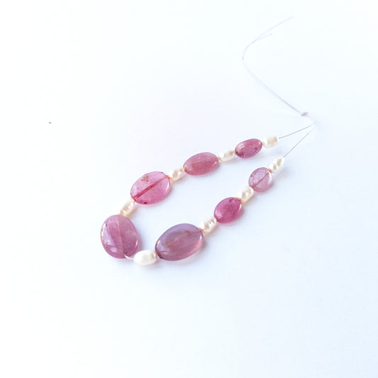 Ruby and freshwater pearl smooth oval beads shown as 15 pieces totalling 45 carats for jewellery making.
