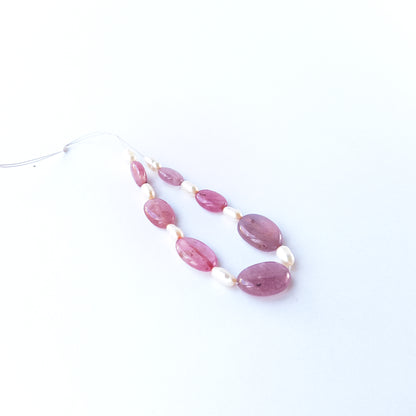 Seven Ruby smooth oval beads displaying rich red tones, sized 9.2–14.7mm × 6.6–10.9mm.