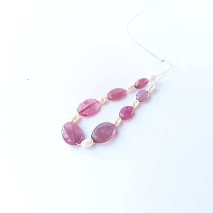 Close‑up of Ruby and freshwater pearl beads highlighting polished surfaces and contrasting textures.