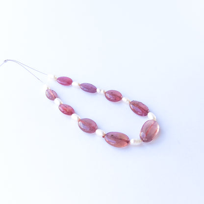 Nine Ruby smooth oval beads displaying deep red tones, sized 10–15mm × 7–9.5mm.