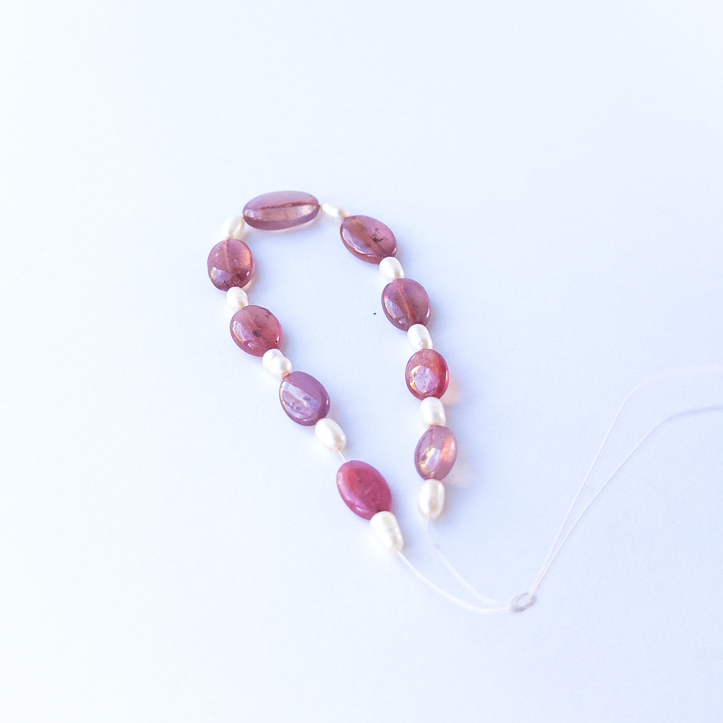 Close‑up of Ruby and freshwater pearl beads highlighting polished surfaces and contrasting textures.
