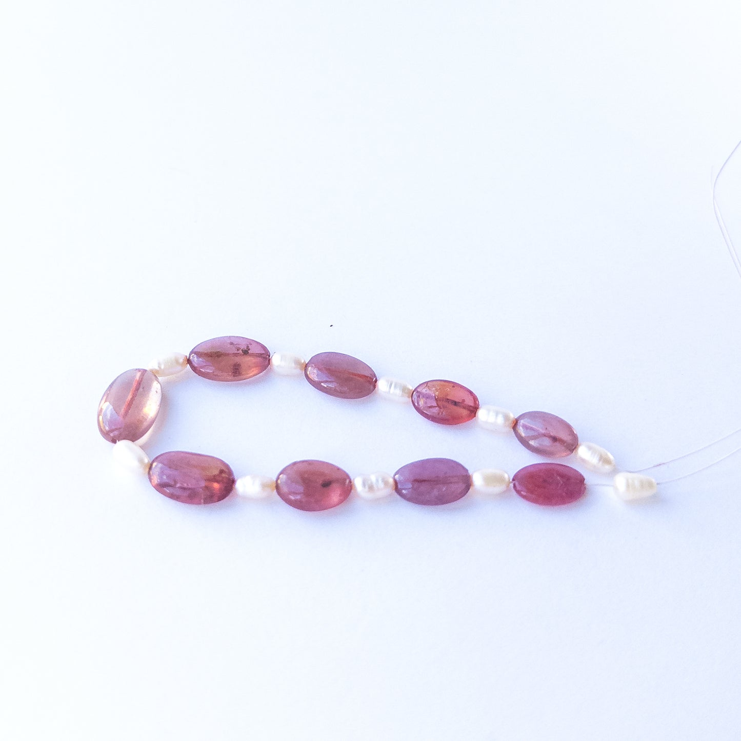 Handmade jewellery components featuring Ruby smooth ovals paired with baroque freshwater pearls.