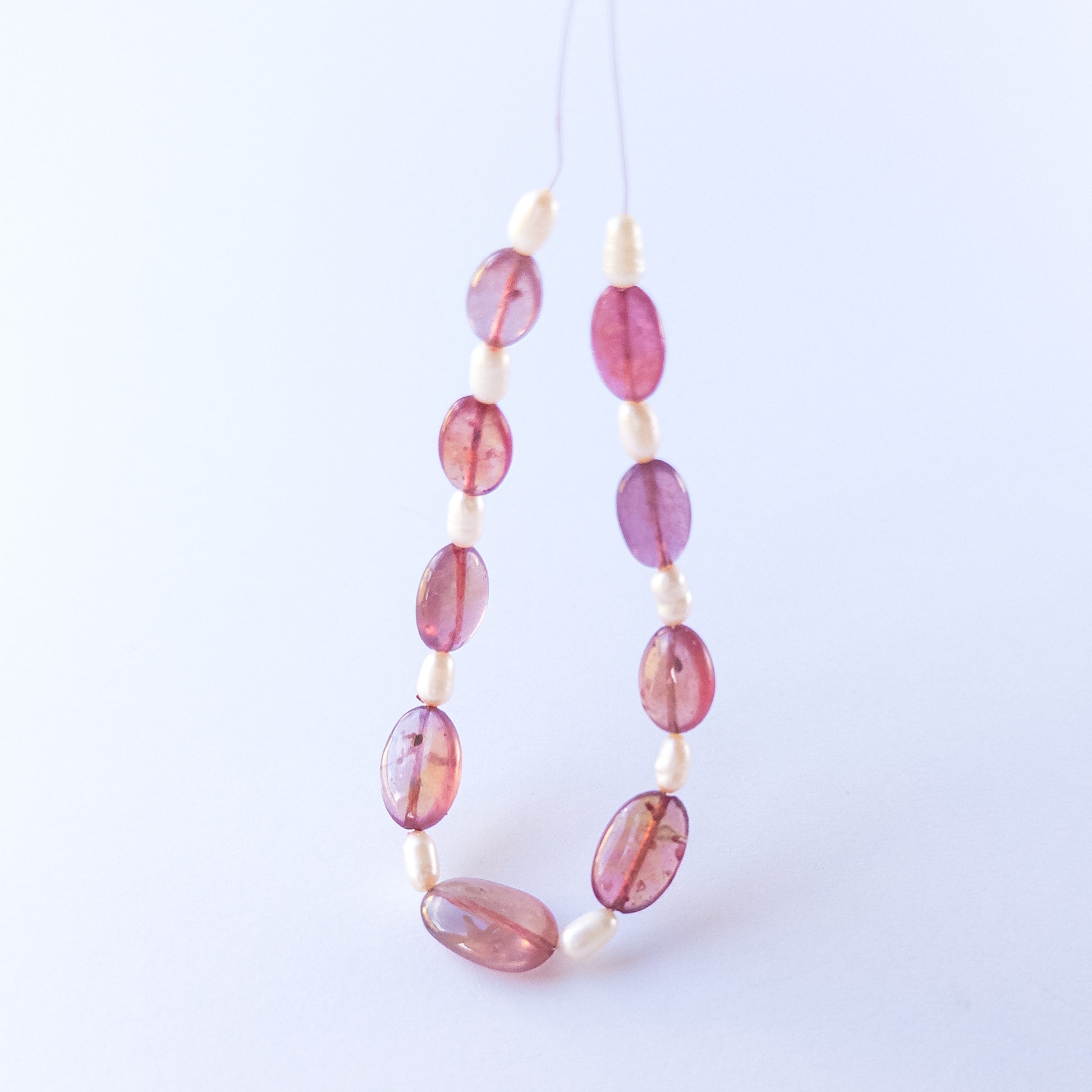 Ruby and freshwater pearl beads highlighting polished surfaces and contrasting textures.