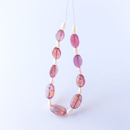 Ruby and freshwater pearl beads highlighting polished surfaces and contrasting textures.