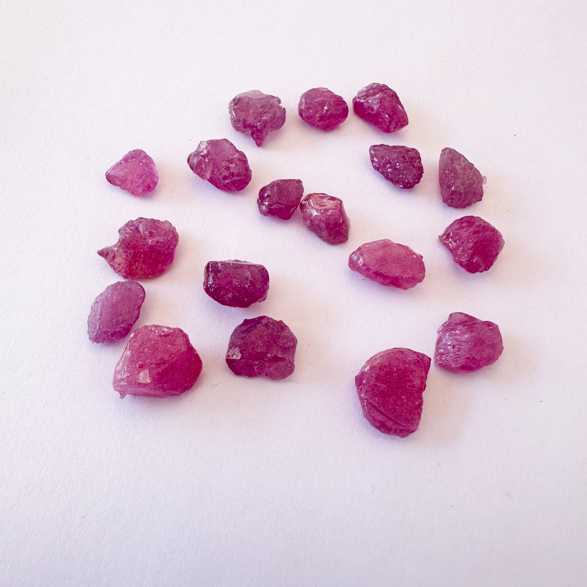 Ruby roughs arranged in a cluster, highlighting their organic shape and shine.