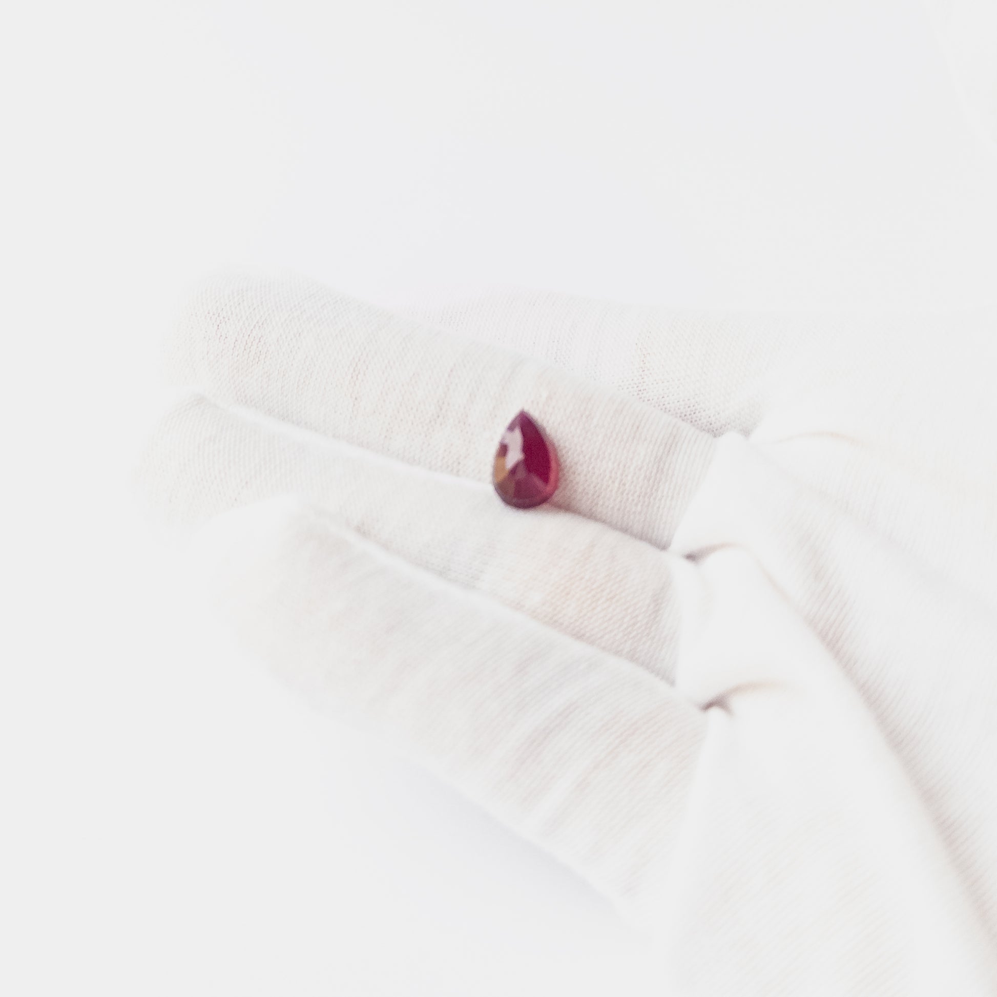 Close‑up of Ruby pear cabochon showing polished surface, natural inclusions and high‑quality gemstone shine.