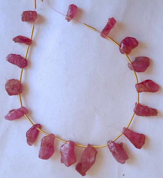 Close-up of 17 ruby gemstone pieces showing raw edges and vibrant colour saturation.