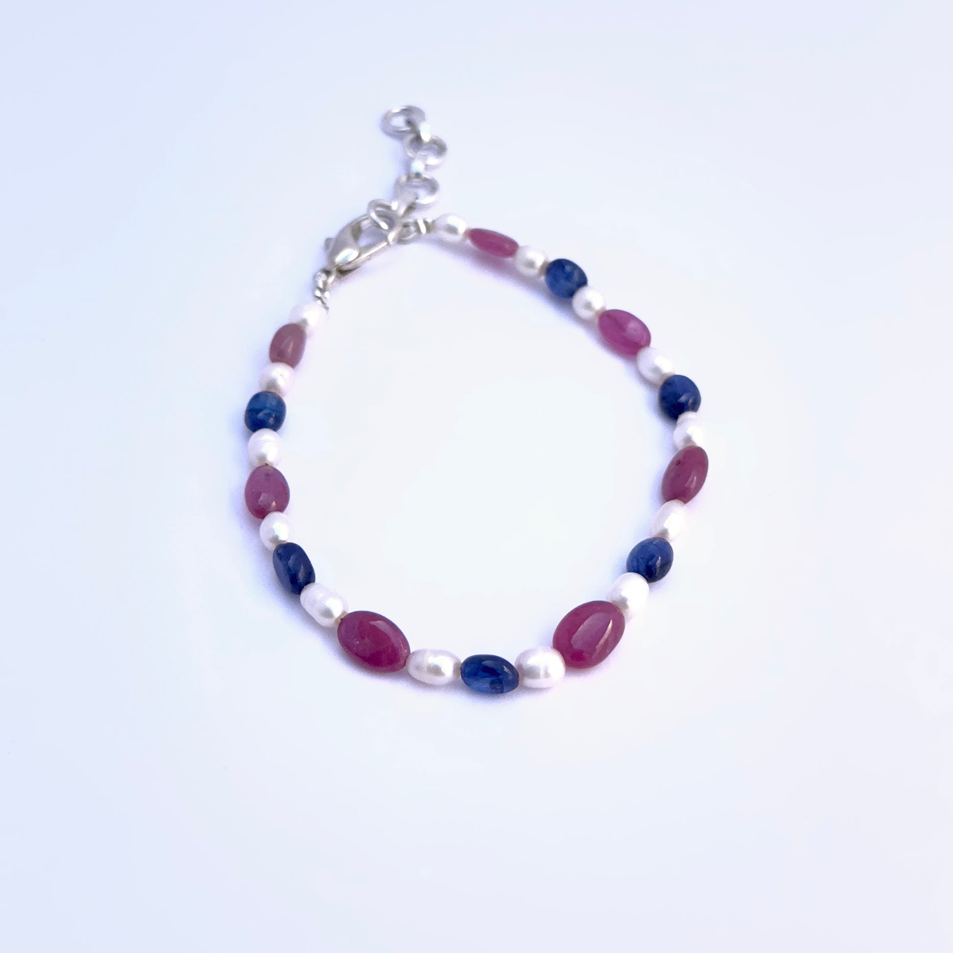 Ruby, Sapphire, and Pearl bracelet with smooth finish and adjustable clasp for versatile styling.