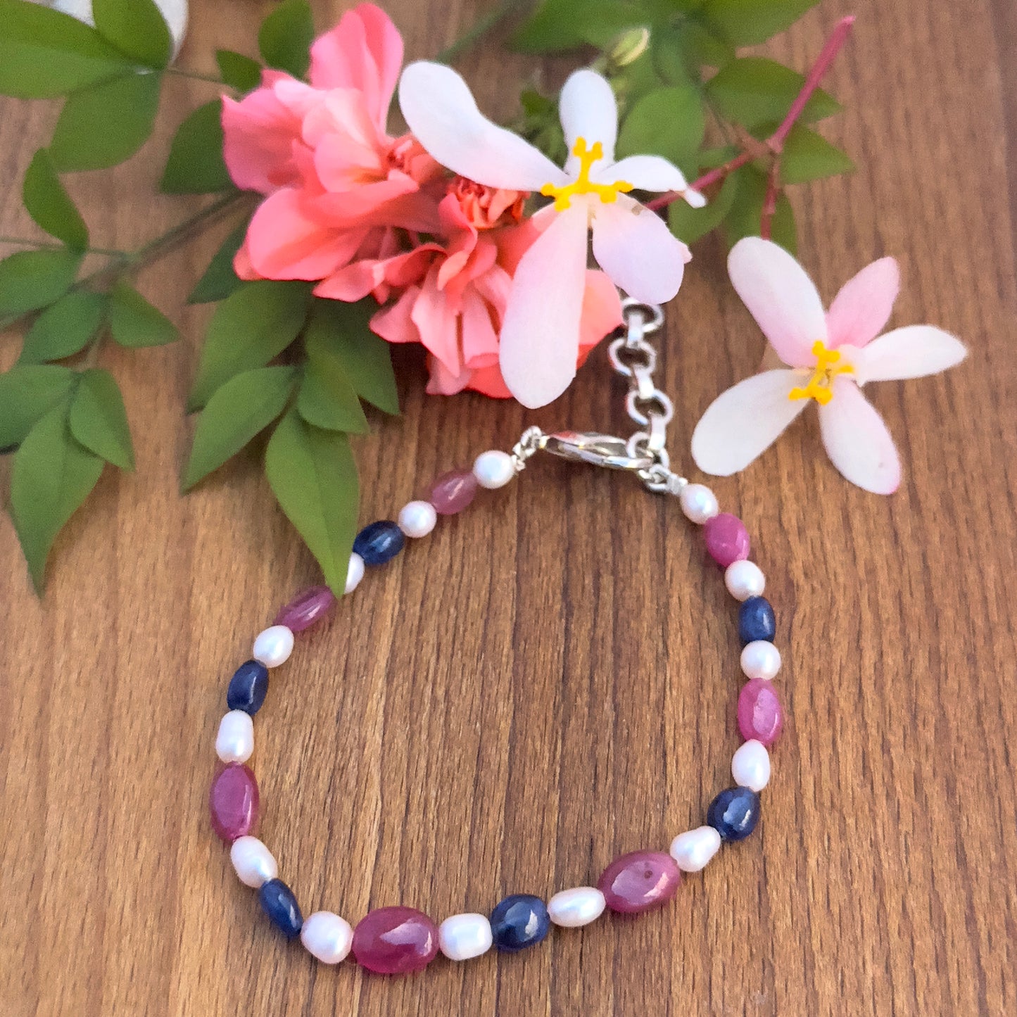 Natural gemstone beads bracelet with vibrant Ruby, Sapphire, and lustrous Pearls in oval cut.