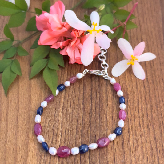 Natural gemstone beads bracelet with vibrant Ruby, Sapphire, and lustrous Pearls in oval cut.