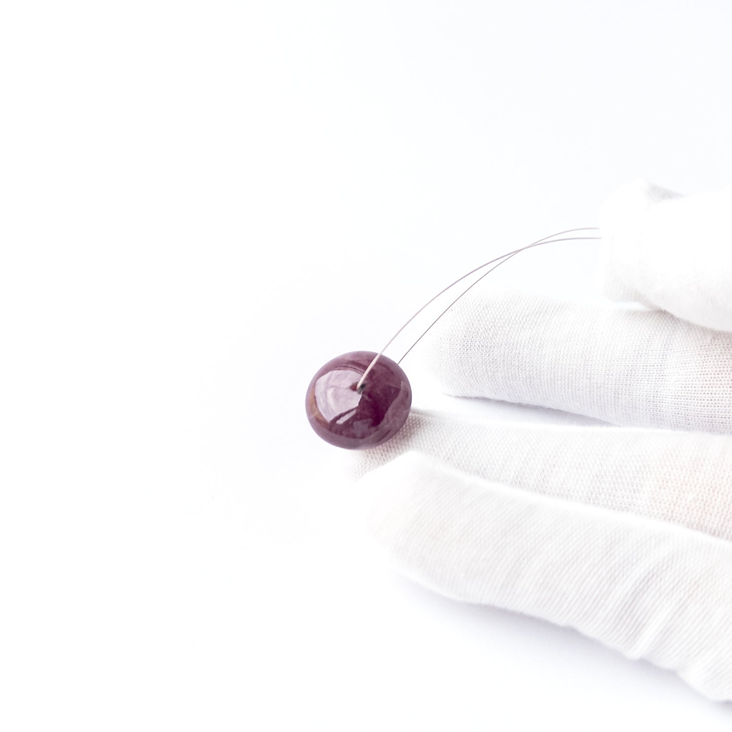 Close‑up of Ruby smooth disc cabochon showing natural inclusions, glossy shine and high‑quality craftsmanship.